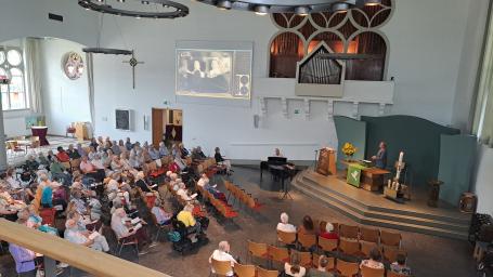 De kerkzaal met de bezoekers..